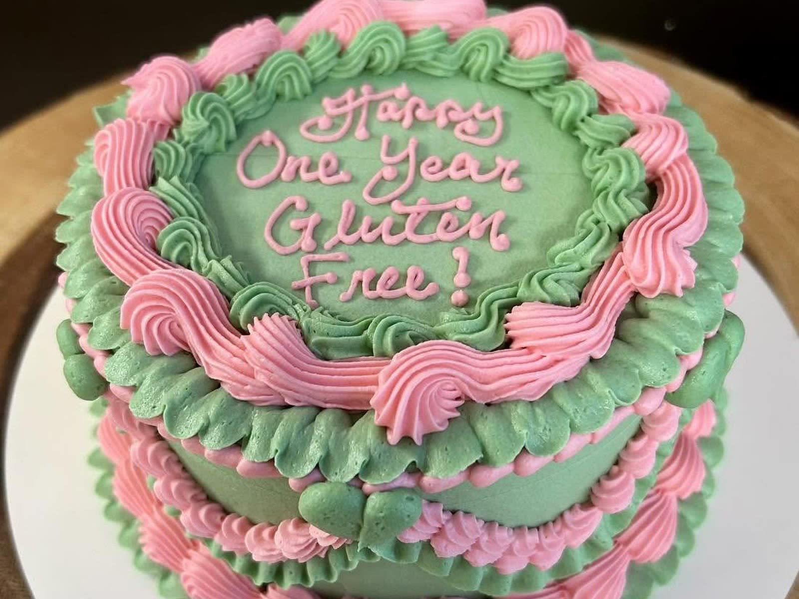 A custom gluten-free celebration cake piped in vintage green and pink buttercream