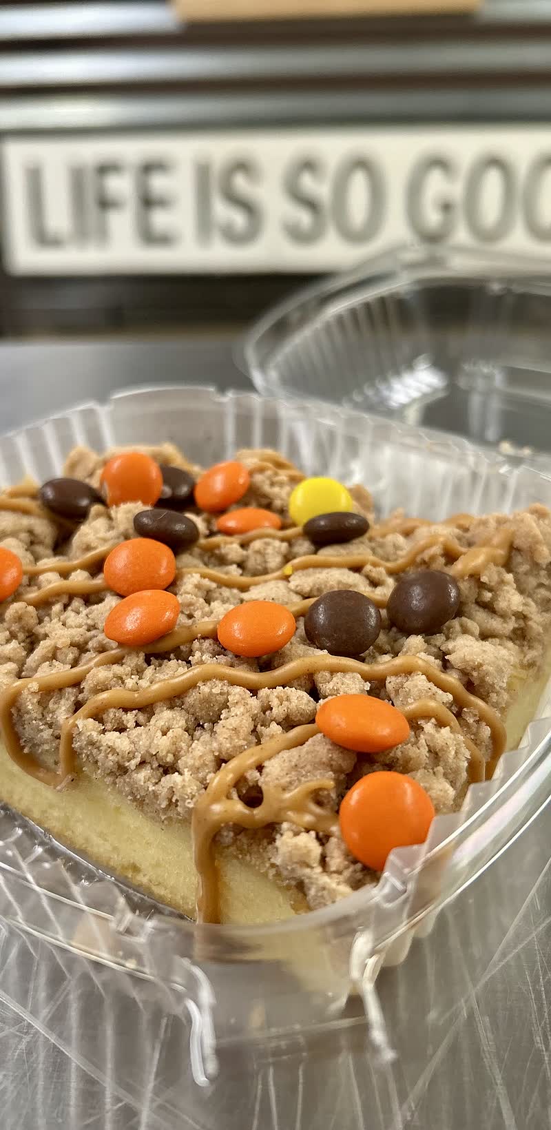 A gluten-free peanut butter crumb cake slice scattered with Reese&rsquo;s Pieces